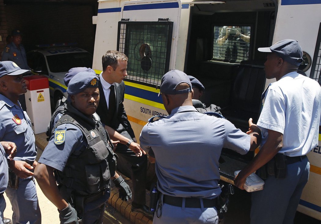 Oscar Pistorius míří do policejního auta, které ho odveze do věznice