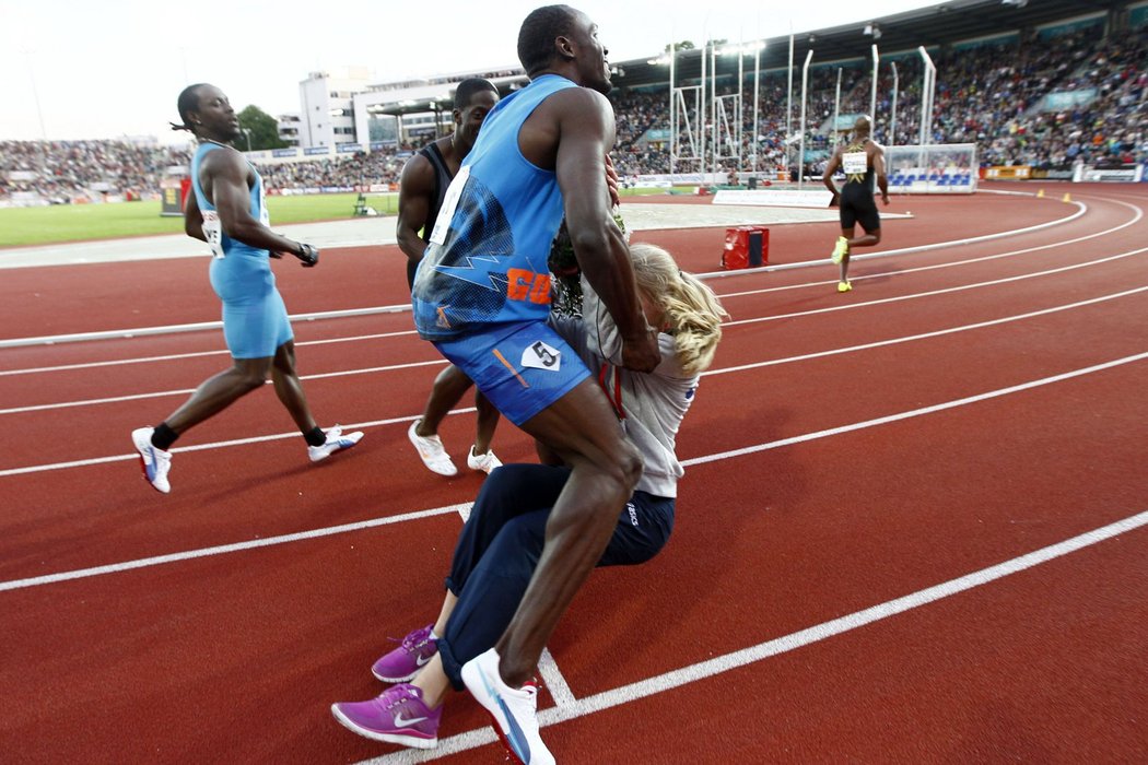 Pod nohy se Usainu Boltovi připletla hosteska s kyticí pro vítěze