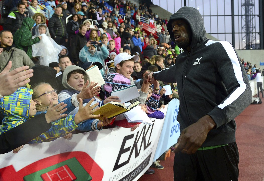 Jamajský sprinter Usain Bolt rozdává autogramy.