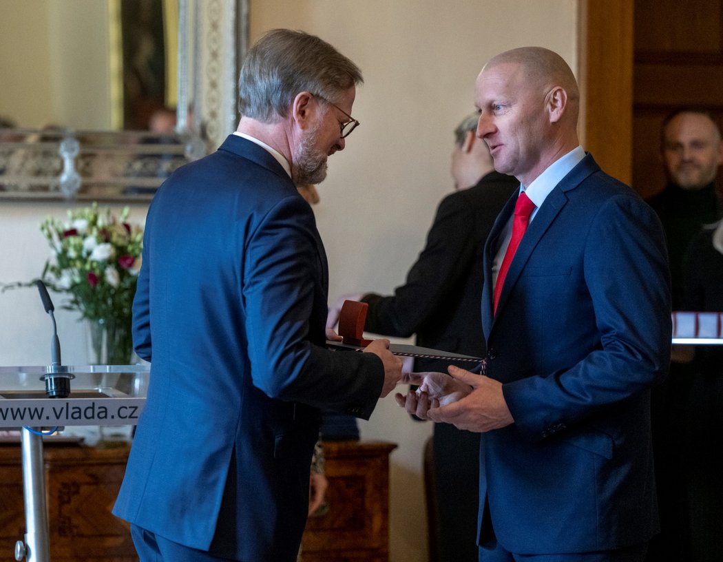 Předseda vlády Petr Fiala předává ocenění trenérovi Pavlu Chadimovi