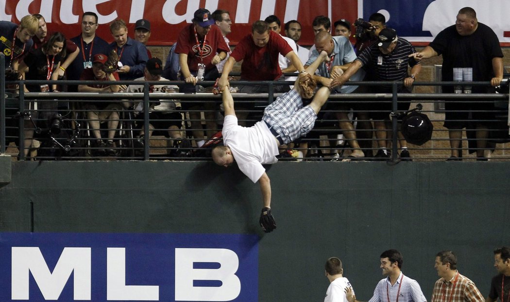 Basebalový fanoušek Keith Carmickle se vrhl po míčku při Utkání hvězd MLB a mohl děkovat bohu, že ho jeho bratr a kamarád chytili