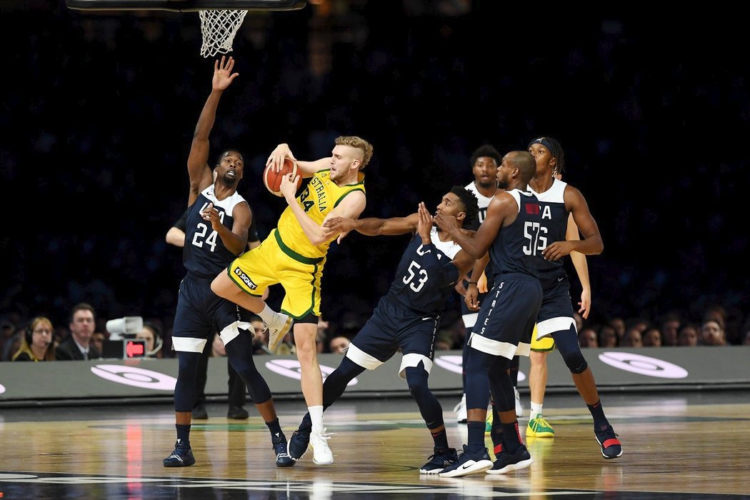 Australan Jock Landale doskakuje mezi americkými basketbalisty v přípravném zápase před MS na fotbalovém stadionu v Melbourne