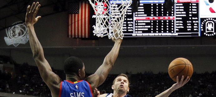 Dallaský J. J. Barea zakončuje přes Henryho Simse v zápase proti Philadelphii