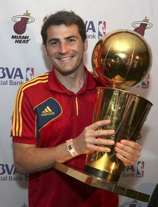 Brankář fotbalistů Španělska Iker Casillas s trofejí pro vítěze NBA. Španělští fotbalisté si před Pohárem FIFA užívali i basketbalového svátku