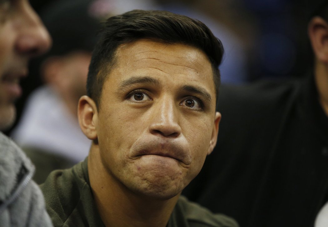 Hvězda Arsenalu Alexis Sánchez sleduje zápas basketbalové NBA v Londýně