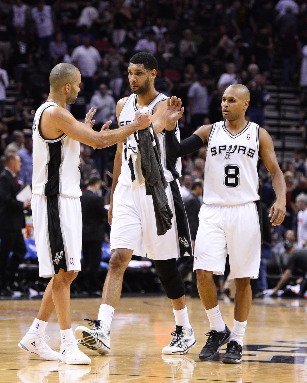 Zleva Tony Parker, Tim Duncan a Patty Mills ze San Antonia se radují v průběhu druhého semifinále NBA proti Oklahomě