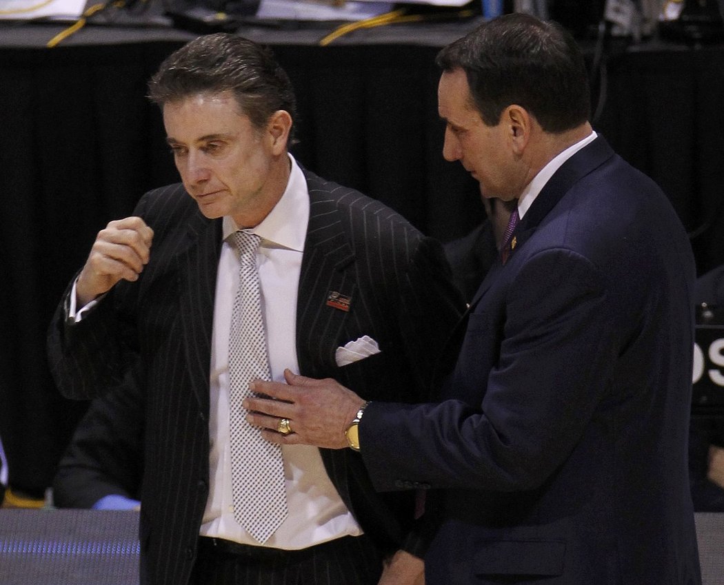 Šokovaný trenér Louisville Rick Pitino je uklidňován svým protějškem Mikem Krzyzewskim