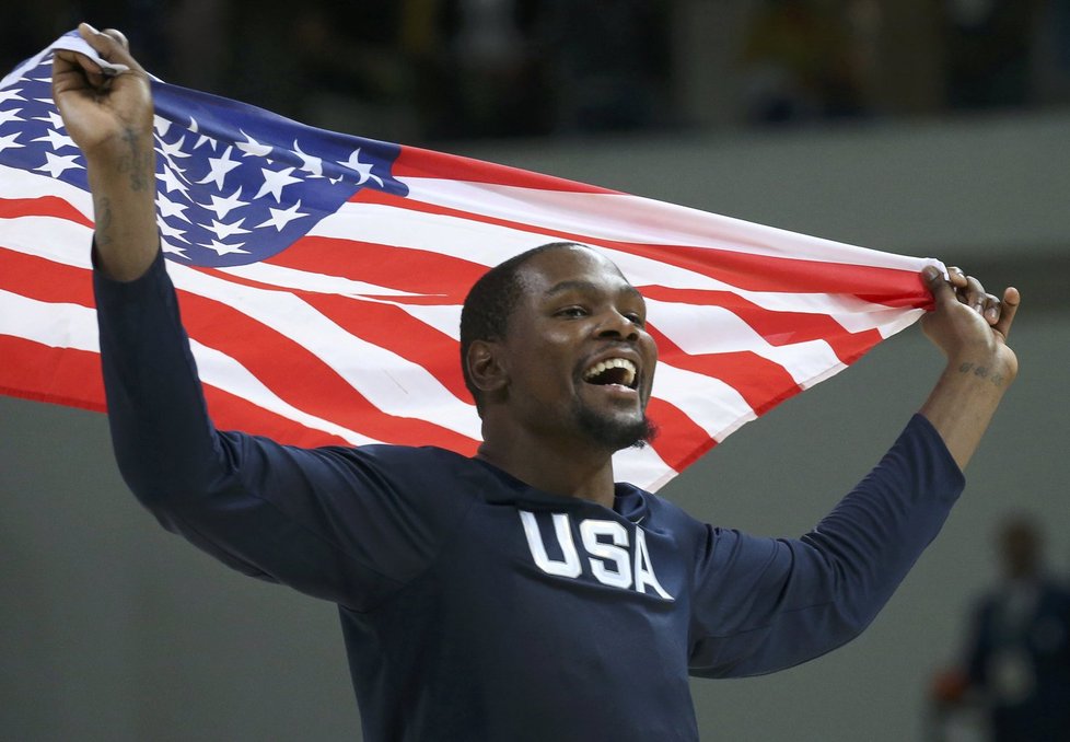 Kevin Durant s americkou vlajkou slaví olympijské zlato.