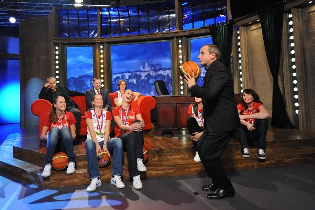 Moderátor Jan Kraus háže na koš. Před tím dostal instrukce od stříbrných basketbalistek