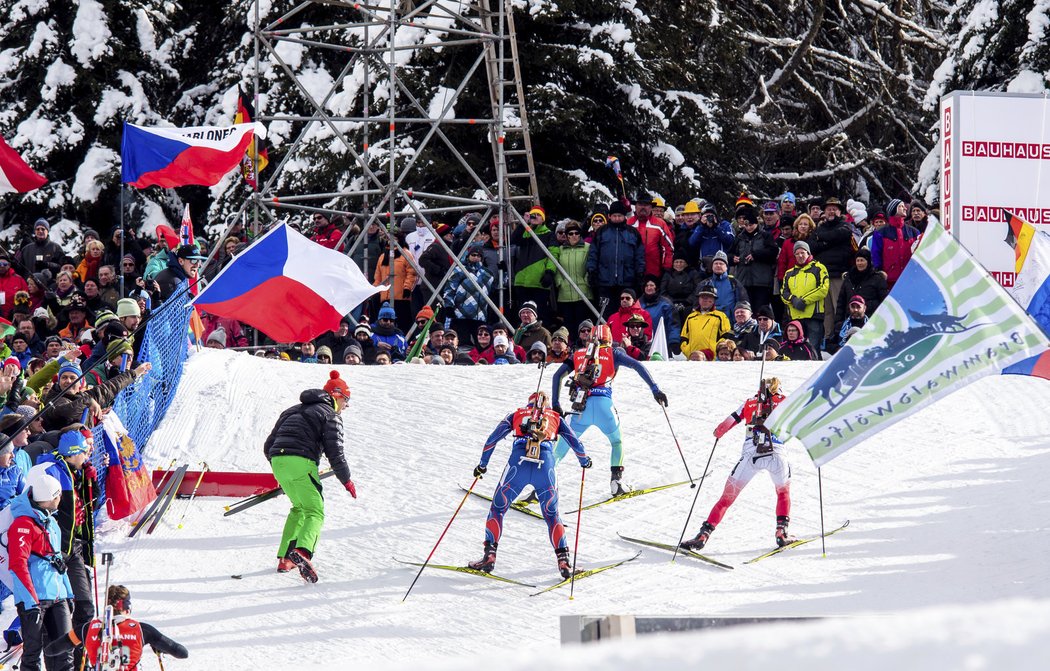 Člen českého týmu dává informace na trati jedné z českých biatlonistek