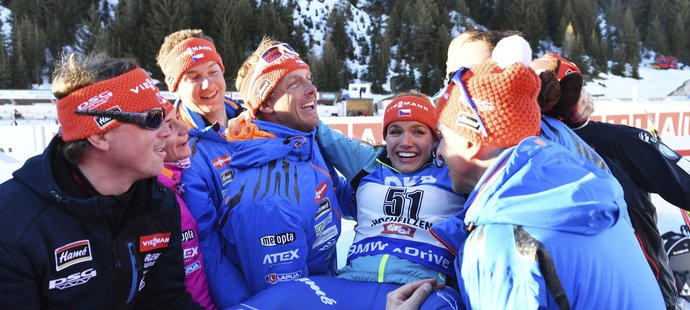 Gabriela Koukalová v rukou českého realizačního týmu poté, co jí jako stříbrné medailistce z individuálního závodu dali hobla