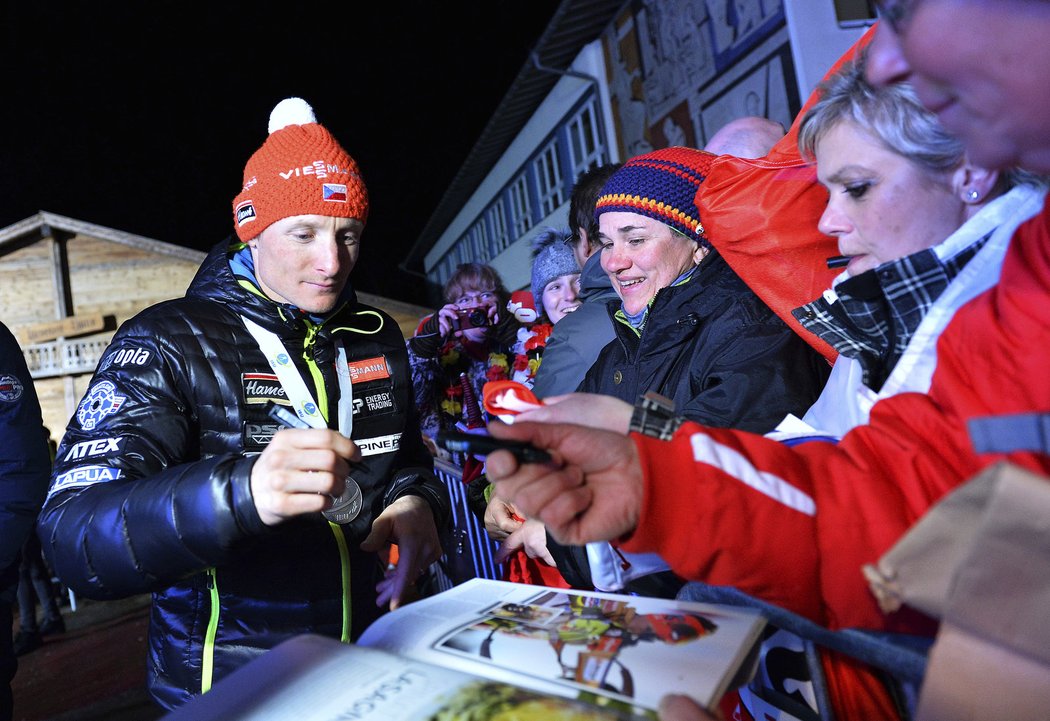 Ondřej Moravec se stříbrnou medailí na krku se podepisuje českým fanouškům v Hochfilzenu