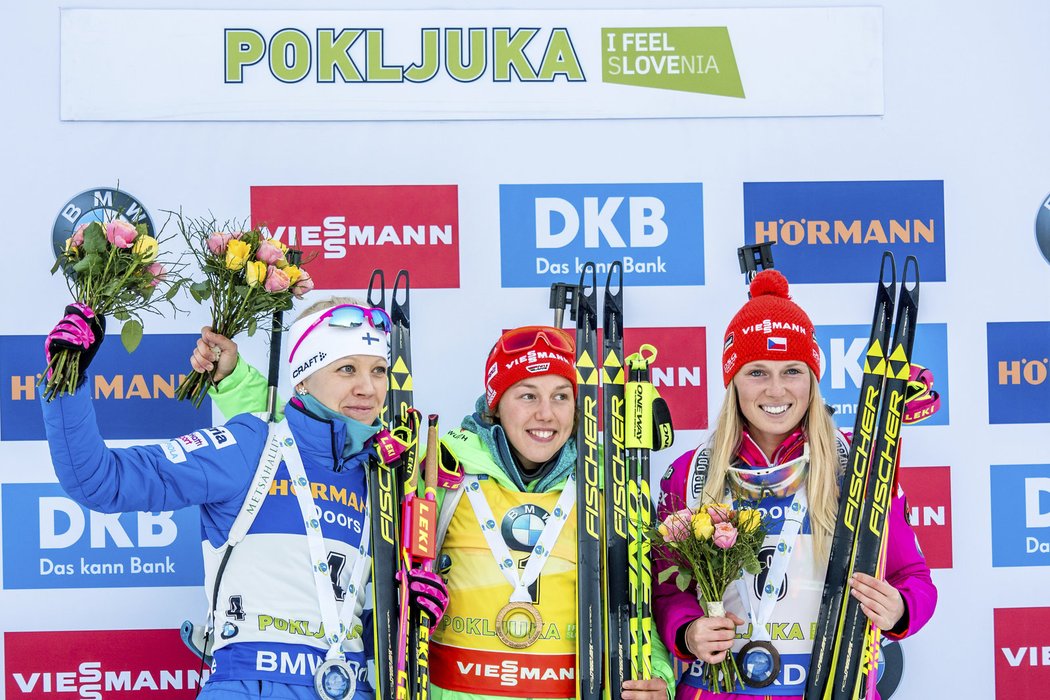 Eva Puskarčíková (vpravo) se svou bronzovou medailí na stupních vítězů s první Laurou Dahlmeierovou a stříbrnou Kaisou Mäkäräinenovou