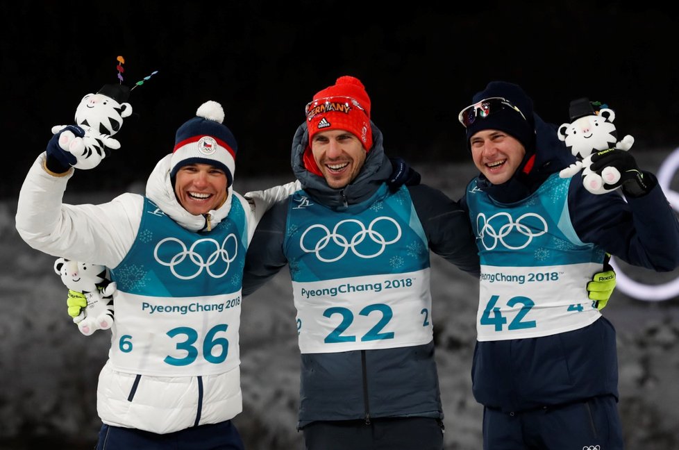 Stupně vítězů po sprintu biatlonistů na olympiádě v Pchjongčchangu. Vlevo se raduje stříbrný Michal Krčmář