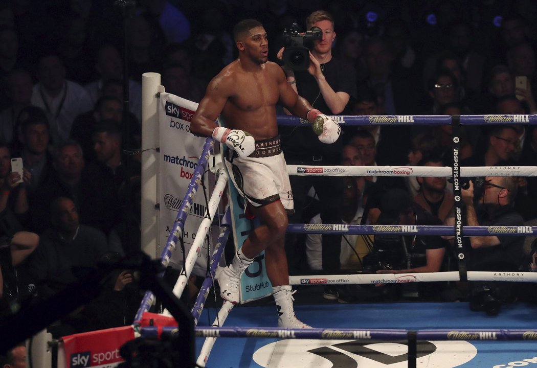 Anthony Joshua čeká ve svém rohu poté, co rozhodčí předčasně ukončil zápas s Carlosem Takamem