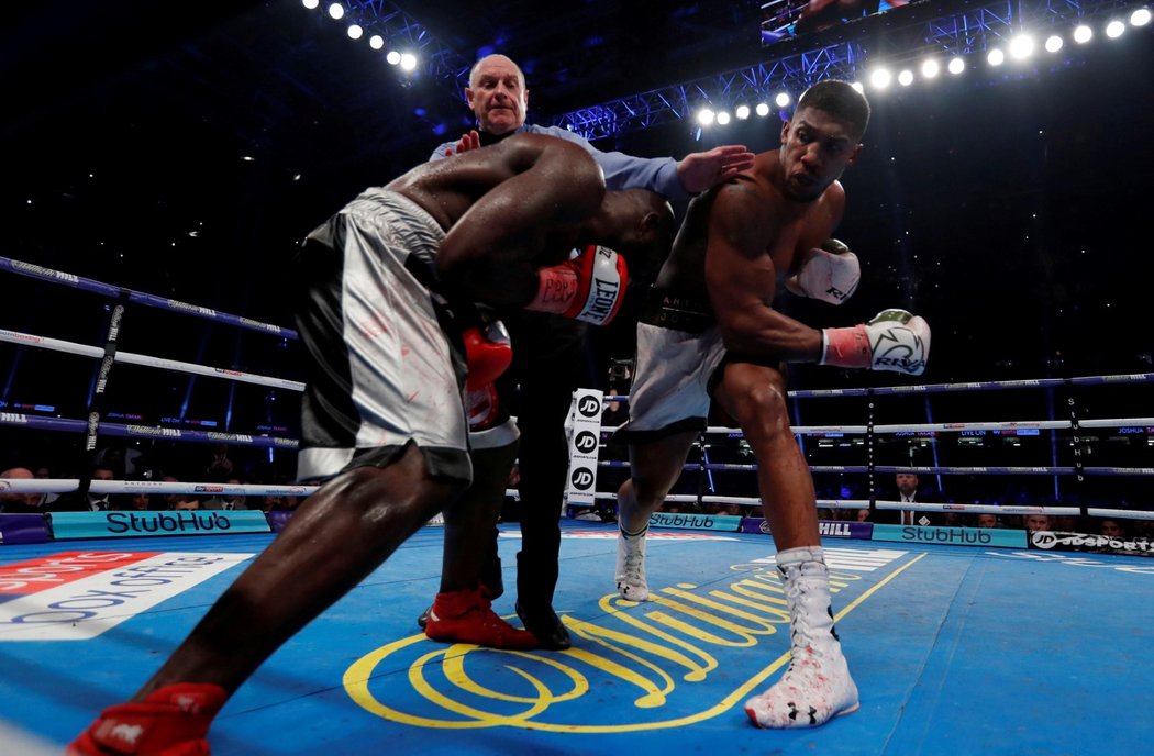 Anthony Joshua ještě trefuje Carlose Takama, kterého se snaží zastavit rozhodčí