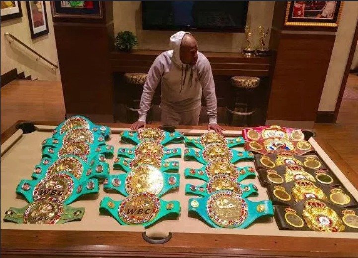 Floyd Mayweather a všechny pásy, které v ringu vybojoval, pohromadě.