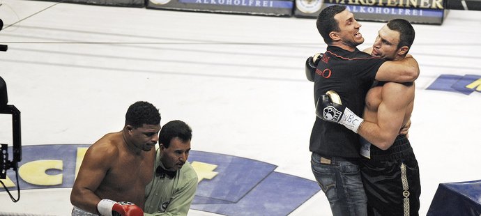 Vladimir Kličko objímá svého bratra Vitalije poté, co ukončil duel o světový titul s Kubáncem Solísem