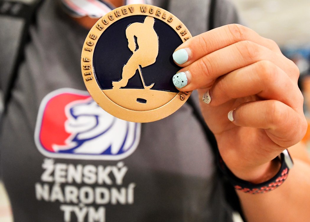 České hokejistky na letišti ukázaly bronzové medaile