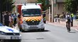 Cyklista při prohlídce trati na Critériu du Dauphiné míjí ambulanci, ve které právě ošetřují vážně zraněného Chrise Frooma