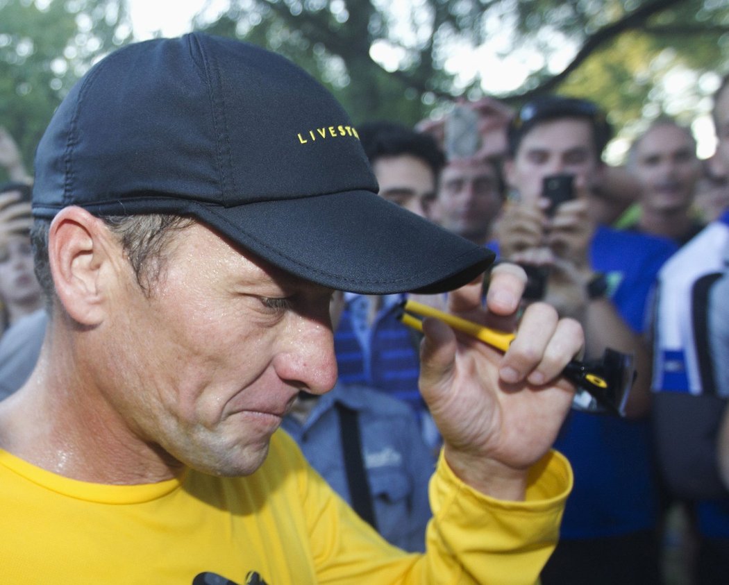 Lance Armstrong se vrací ke svému autu poté, co si zaběhal s fanoušky v Mount Royal parku