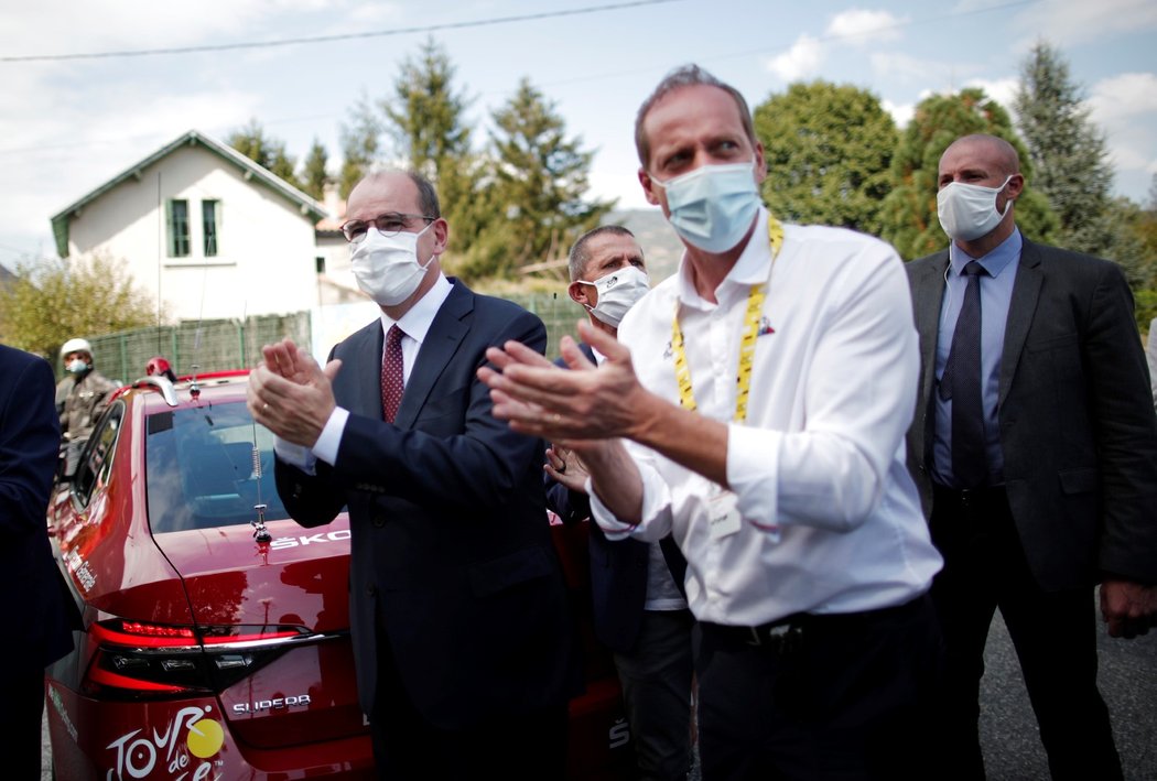 Francouzský předseda vlády Jean Castex (vlevo) a Christian Prudhomme tleskají závodníkům na Tour de France