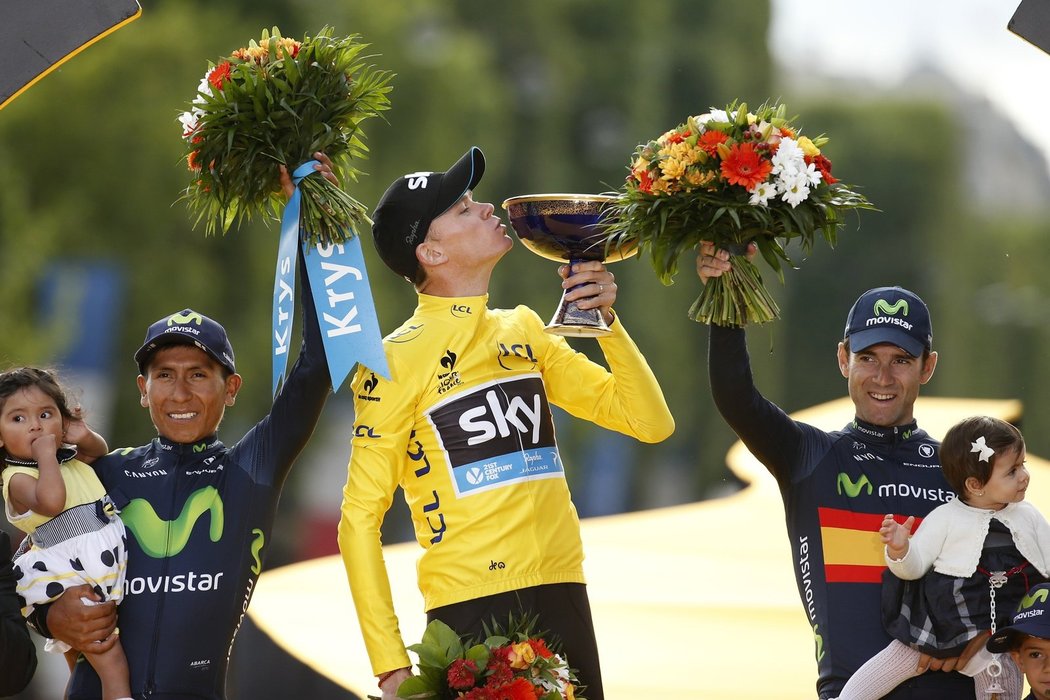 Chris Froome líbá pohár pro vítěz Tour de France, vlevo celkově druhý Nairo Quintana, vpravo třetí muž Alejandro Valverde