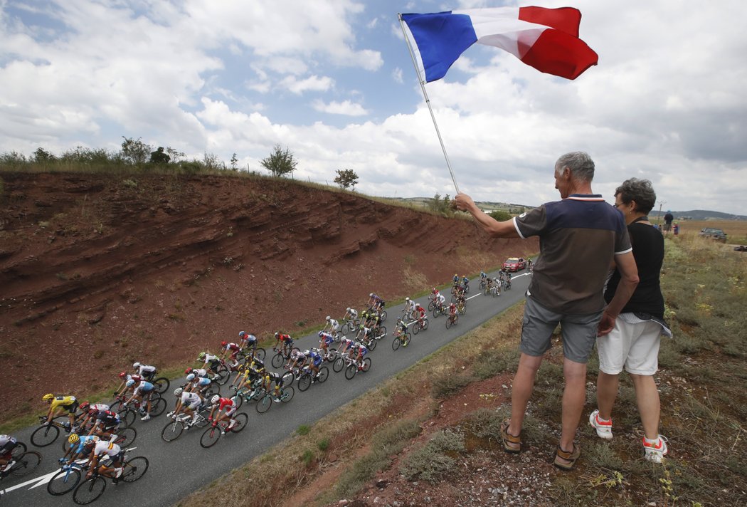 Fanoušci s francouzskou vlajkou sledují průjezd pelotonu během 15. etapy Tour de France