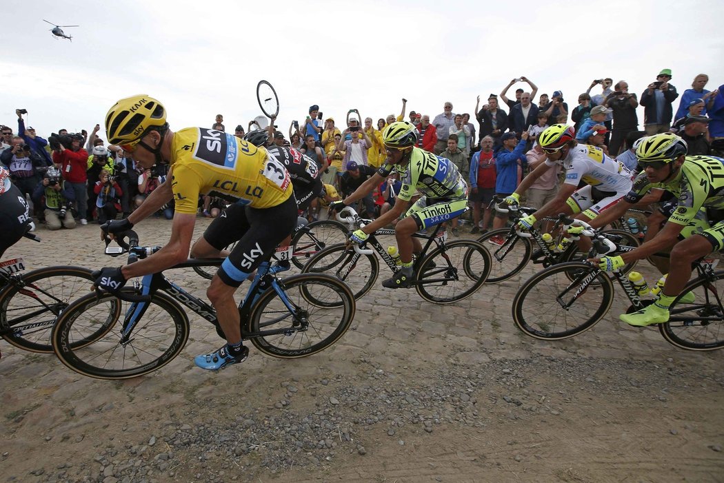 Chris Froome (vlevo) a další cyklisté na trati čtvrté etapy Tour de France, která je zavedla na šest úseků s kostkami na cestě