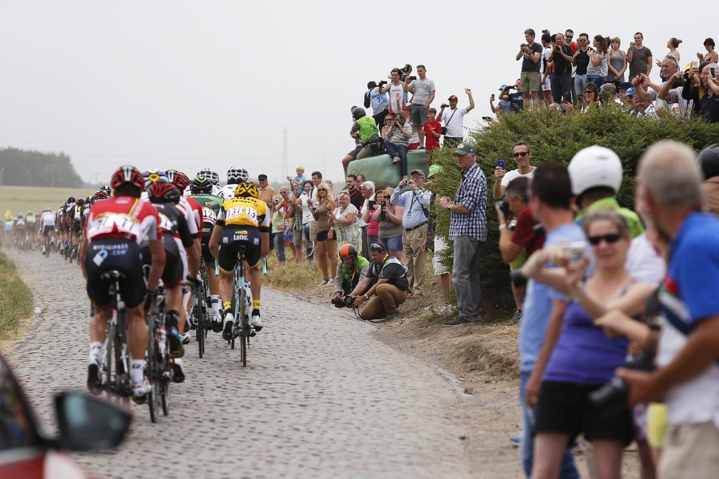 Fanoušci na Tour de France sledují peloton projíždějící po démonizovaných kostkách ve čtvrté etapě