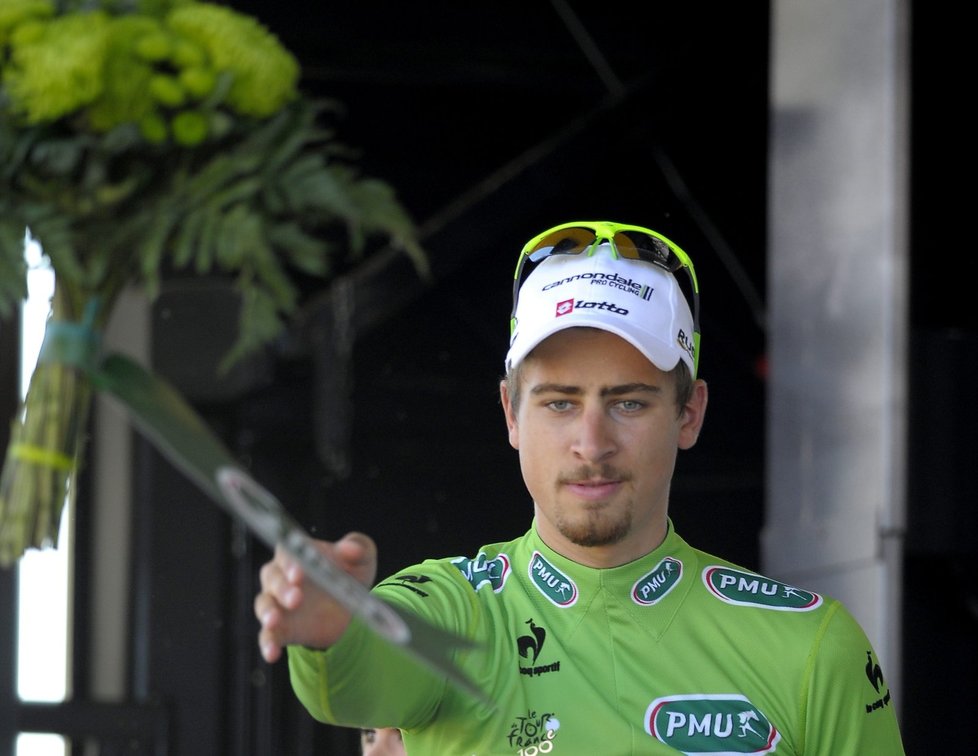 Peter Sagan hází fanouškům kytici poté, co si oblékl na pódiu zelený dres pro nejlepšího sprintera