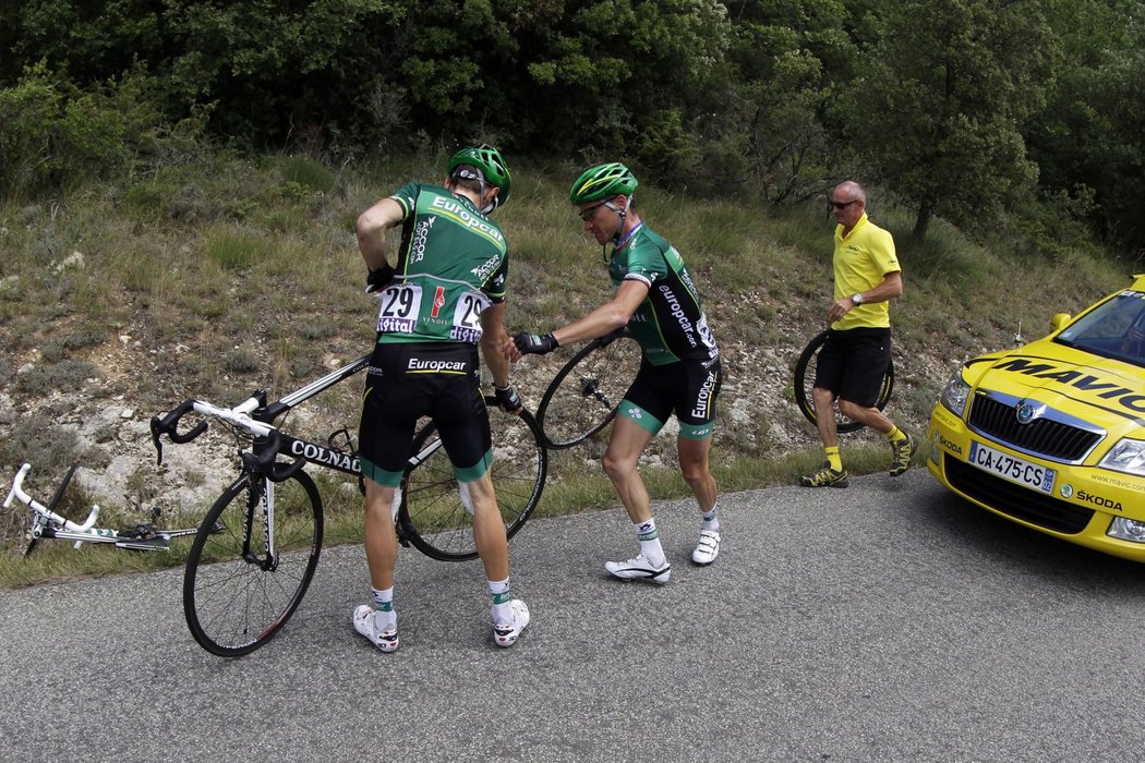 Thomas Voeckler pomáhá vyměnit kolo svému kolegovi z týmu Pierrovi Rollandovi (vlevo)