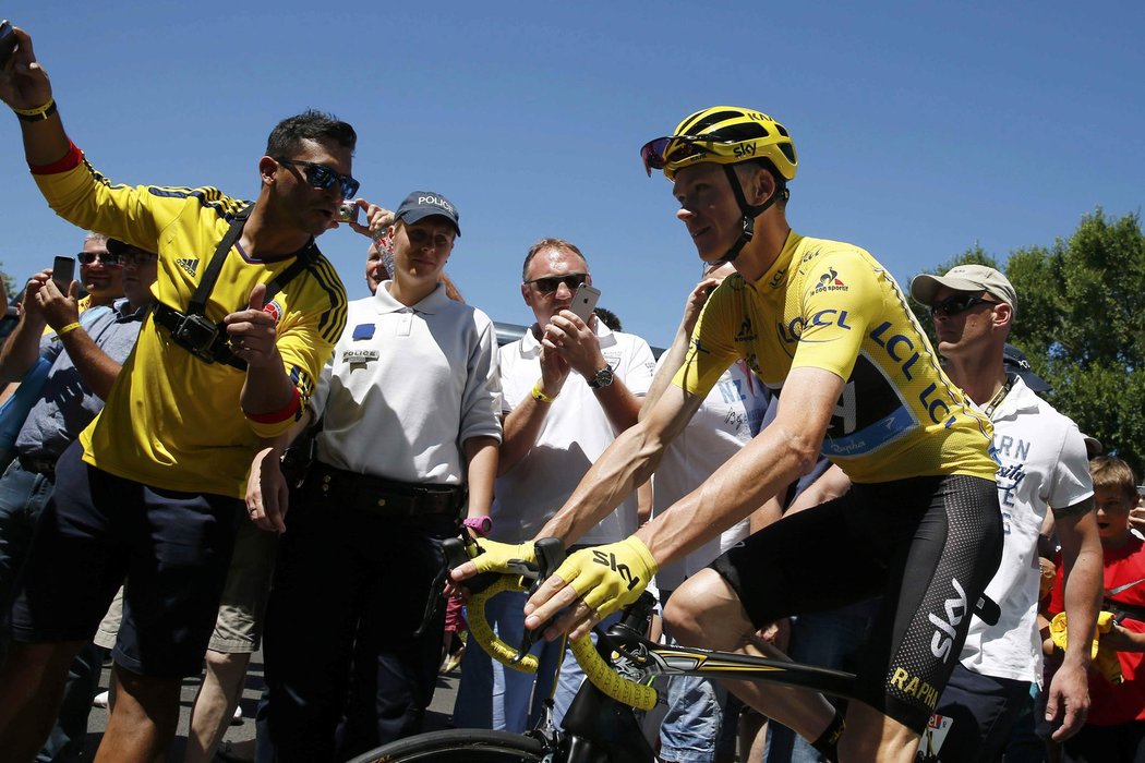 Britský cyklista Chris Froome ve žlutém trikotu lídra Tour de France bojuje v jednom ze stoupání za mohutné podpory fanoušků.