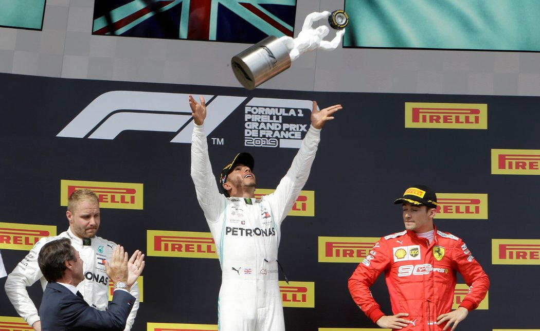 Lewis Hamilton vyhazuje nad hlavu pohár pro vítěze Velké ceny Francie