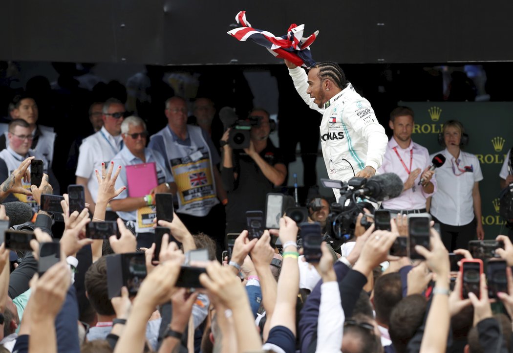 Lewis Hamilton s britskou vlajkou slaví vítězství v domácí Velké ceně