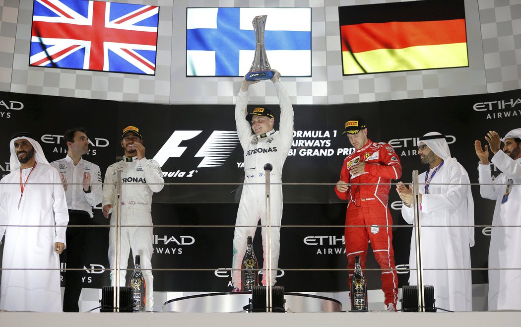 Valtteri Bottas slaví svůj triumf v Abú Zabí, vlevo druhý Lewis Hamilton, vpravo bronzový Sebastian Vettel