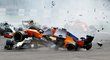 McLaren Fernanda Alonsa dopadá na trať poté, co v první zatáčce vyletěl do vzduchu