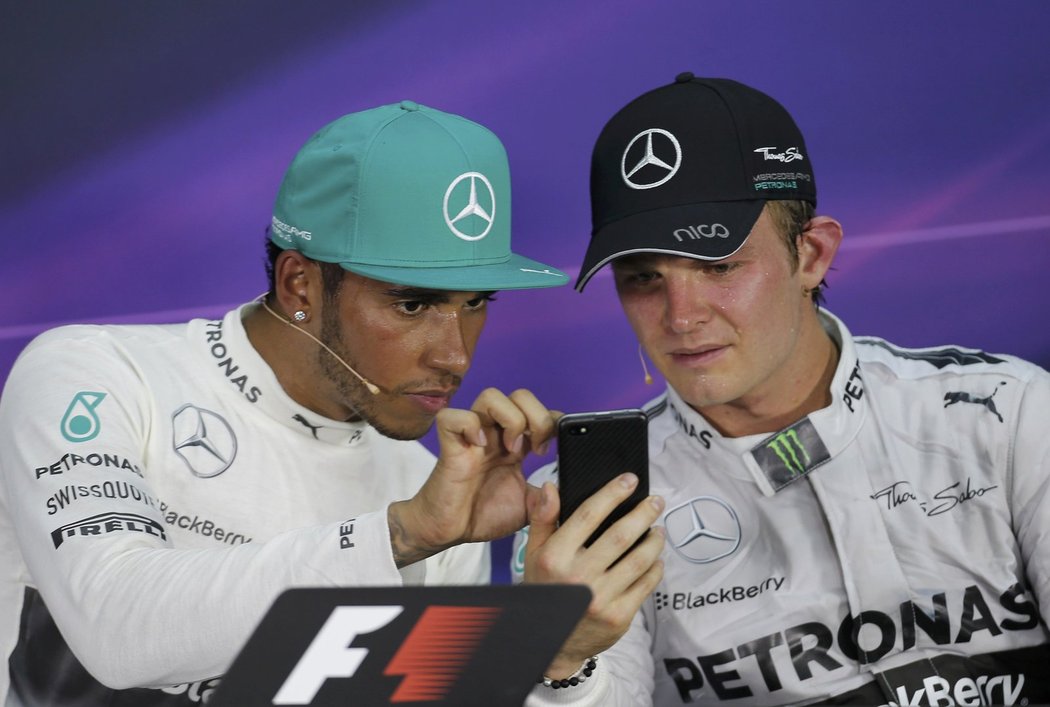 Dva parťáci, které čeká těžký souboj o titul. Ustojí to? Lewis Hamilton a Nico Rosberg (vpravo) si něco prohlížejí na mobilním telefonu před tiskovou konferencí