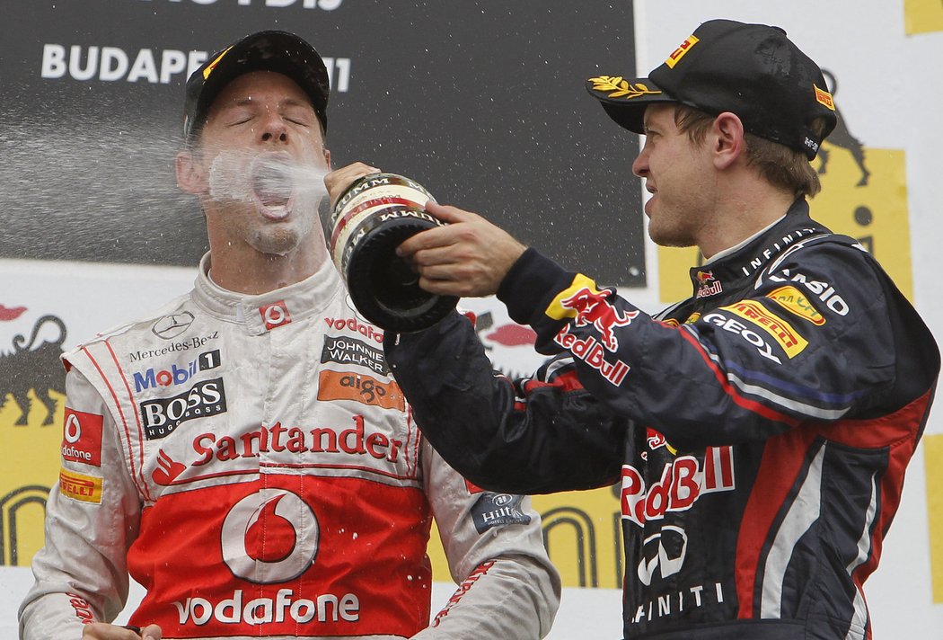 Tentokrát poražený Sebastian Vettel kropí vítěze závodu.