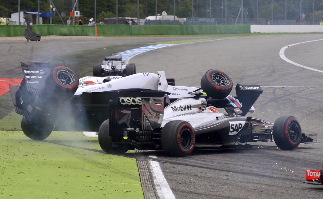 Felipe Massa (vlevo) po kontaktu s Kevinem Magnussenem letí do vzduchu, aby se jeho Williams otočil na střech a zase zpět...