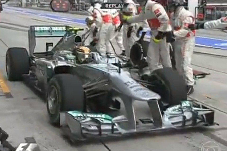 Lewis Hamilton na návštěvě u McLarenu, mechanici mu rukama naznačují, že se spletl