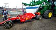 Traťový personál odstraňuje nabouraný monopost Sebastiana Vettela