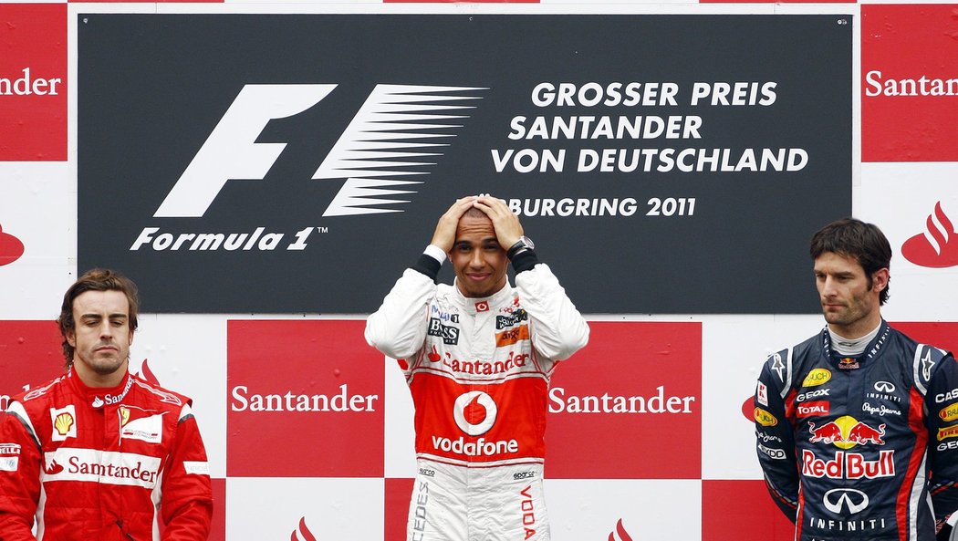 Já jsem fakt vyhrál? Lewis Hamilton na nejvyšším stupni německé GP, vlevo druhý Fernando Alonso, vpravo třetí Mark Webber