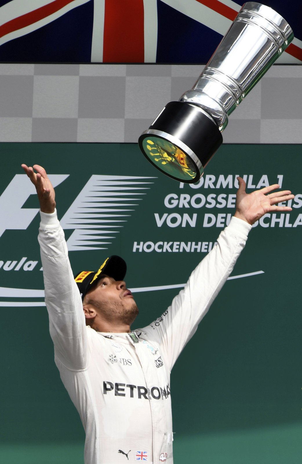 Lewis Hamilton radostně vyhazuje pohár pro vítěze Velké ceny Německa