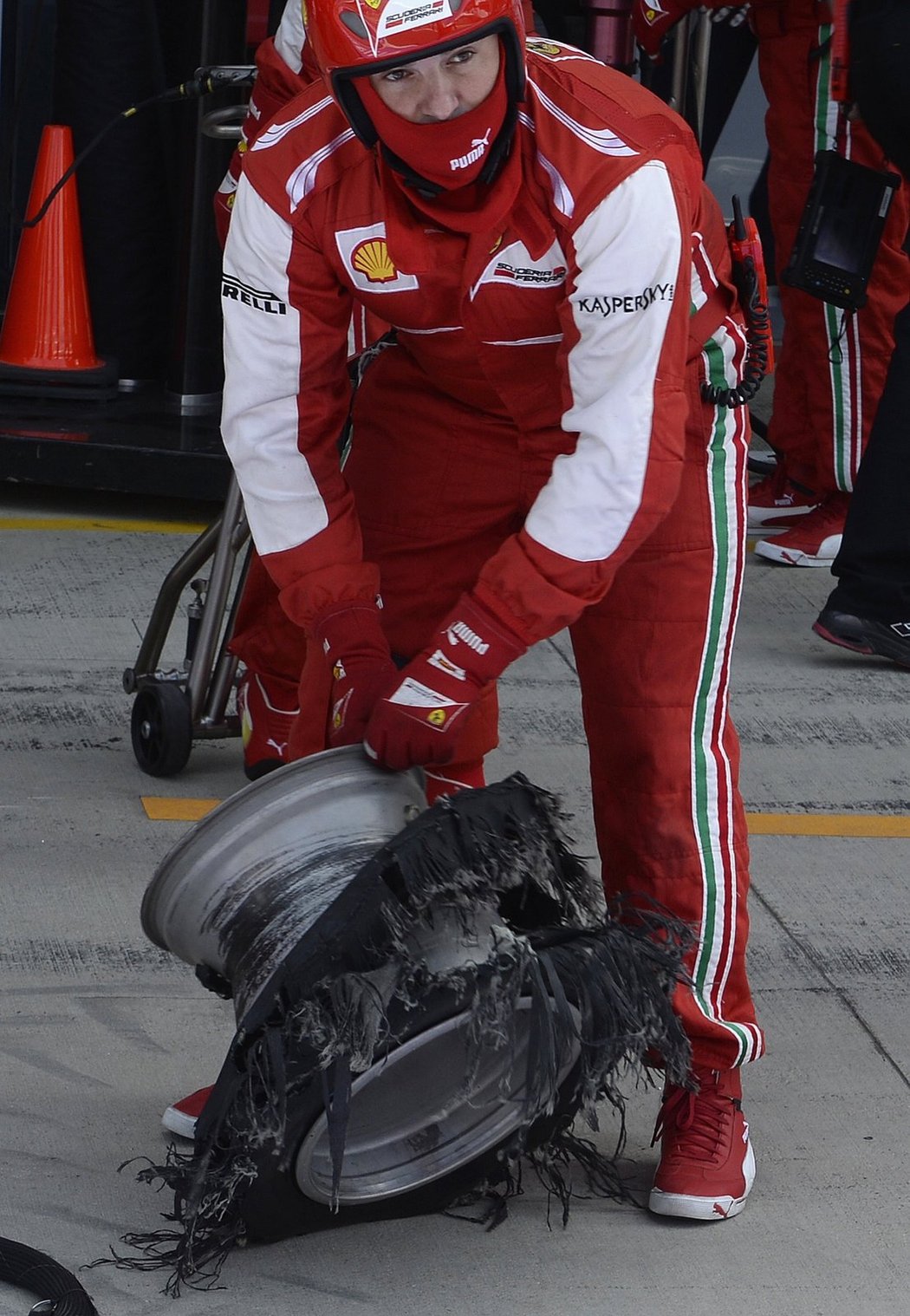 Jeden z mechaniků Ferrari s prasklou pneumatikou Felipeho Massy. Brazilec byl jedním z těch nešťastníků, kterým výbuch kola pokazil závod. Nejsmutnější byl Lewis Hamilton, který tak přišel o vedení...