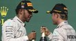 Lewis Hamilton (vlevo) a Nico Rosberg si připíjejí šampaňským po americkém triumfu  britského pilota