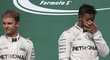 Lewis Hamilton si protírá oči na stupních vítězů po Velké ceně USA, ve které porazil Nica Rosberga (vlevo) a udržel teoretickou šanci na zisk titulu