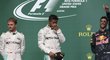 Lewis Hamilton si protírá oči na stupních vítězů po Velké ceně USA, ve které porazil Nica Rosberga (vlevo) a udržel teoretickou šanci na zisk titulu