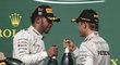 Lewis Hamilton (vlevo) a Nico Rosberg si připíjejí šampaňským po americkém triumfu  britského pilota