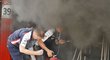 Členové týmu Williams se snaží uhasit plameny, které zachvátily stáj po vítězství ve Velké ceně Španělska